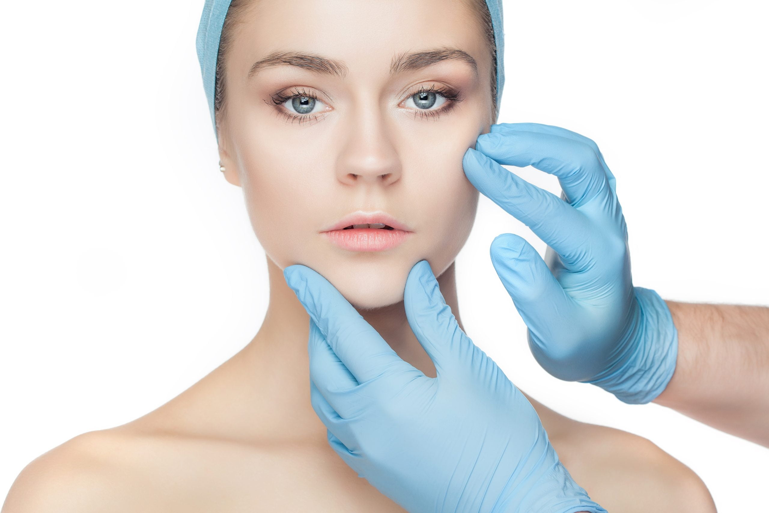 Plastic surgery concept. Doctor hands in gloves touching woman face